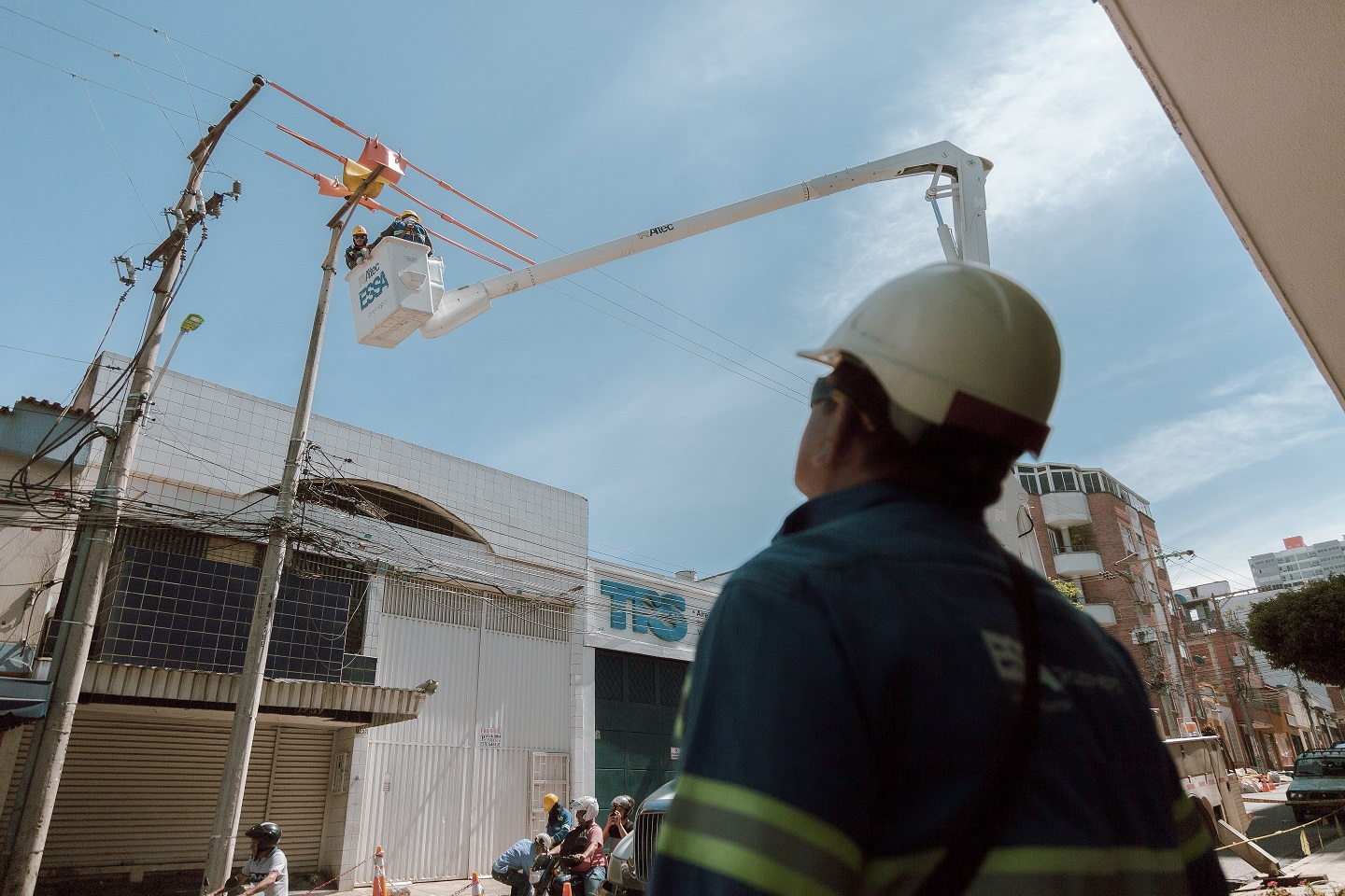 fotografía de trabajador de ESSA mirando a compañeros realizando labores de mantenimiento en las redes urbanas fotografía de trabajador de ESSA mirando a compañeros realizando labores de mantenimiento en las redes urbanas